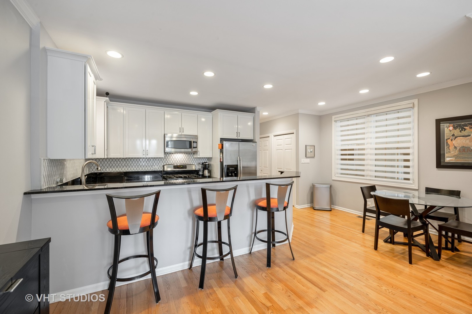 2050 North Racine Avenue, Unit 1 Chicago, IL 60614 - Photo 4 of 25 a kitchen with stainless steel appliances granite countertop a dining table chairs stove refrigerator and cabinets