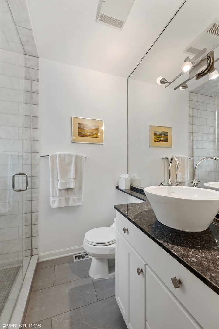 2050 North Racine Avenue, Unit 1 Chicago, IL 60614 - Photo 10 of 25 a bathroom with a granite countertop sink a toilet and a mirror