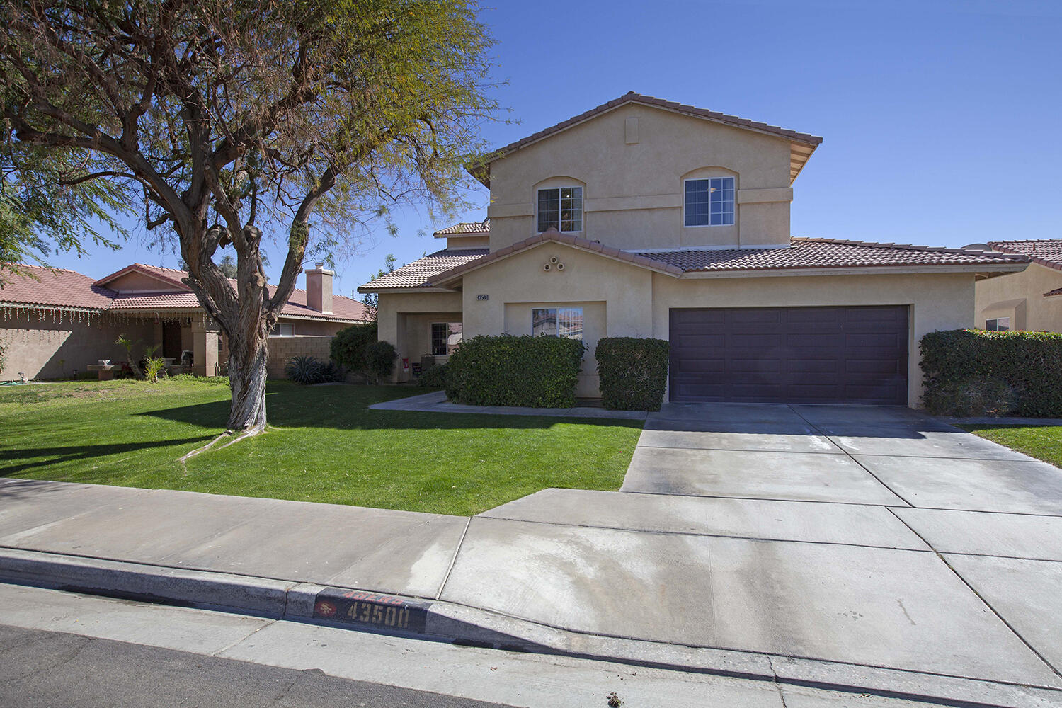 43500 Brahea Court Indio, CA 92201 - Photo 2 of 33 a front view of a house with a yard and garage