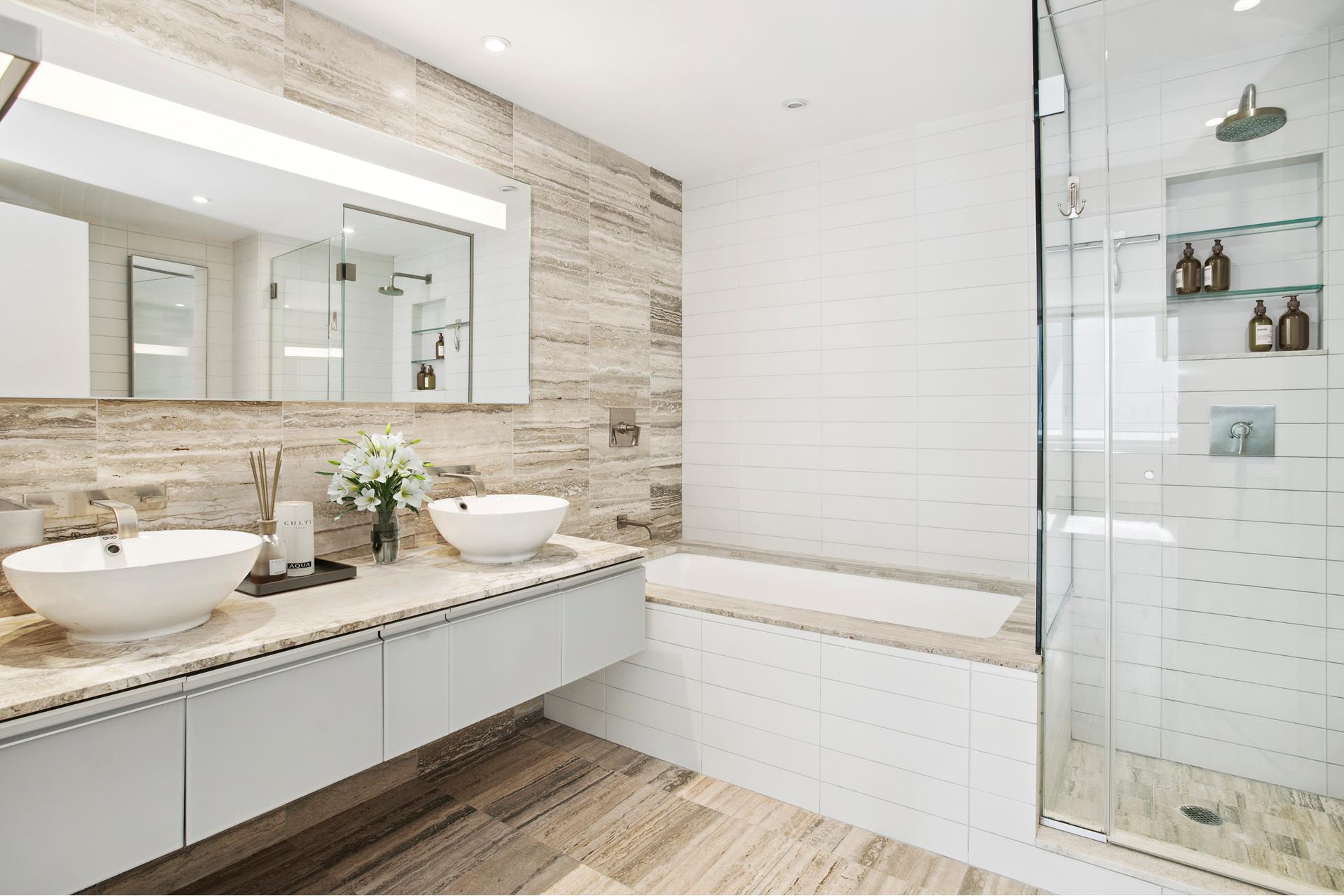 322 West 57th Street, Unit 55S1 Manhattan, NY 10019 - Photo 10 of 33 a bathroom with a double vanity sink a toilet and shower
