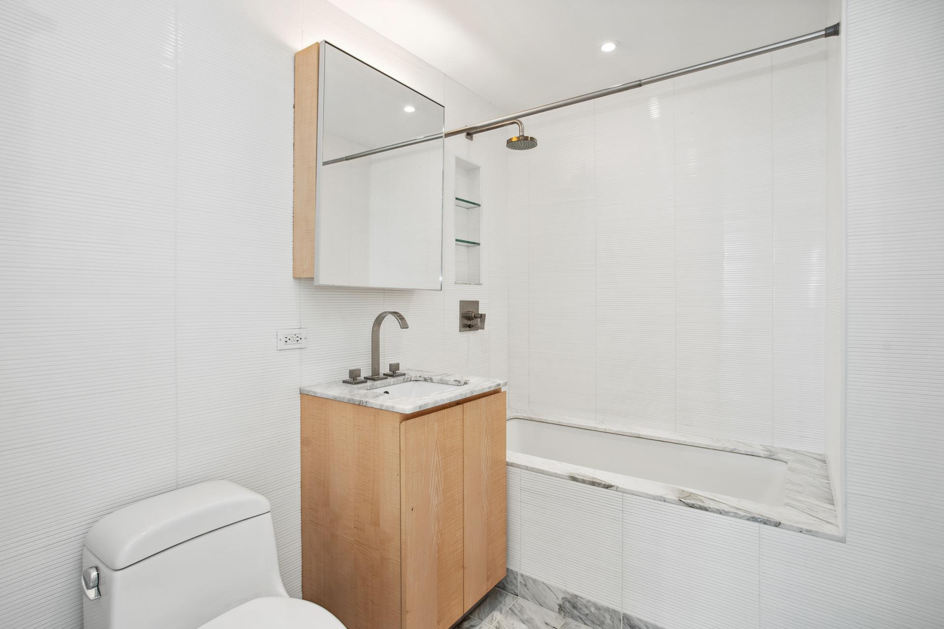322 West 57th Street, Unit 55S1 Manhattan, NY 10019 - Photo 17 of 33 a bathroom with a toilet a sink and vanity