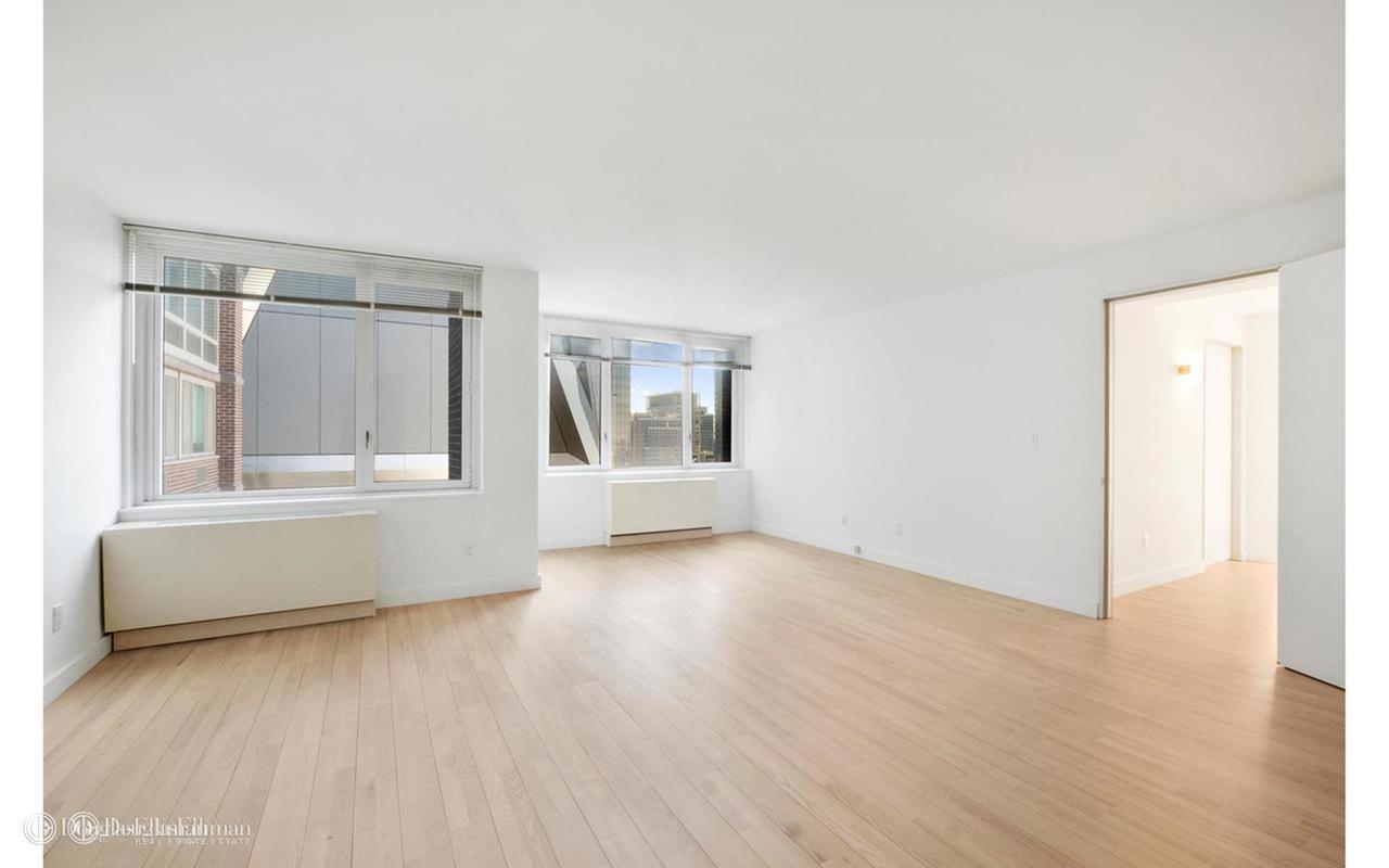 322 West 57th Street, Unit 55S1 Manhattan, NY 10019 - Photo 23 of 33 a view of an empty room with wooden floor and a window