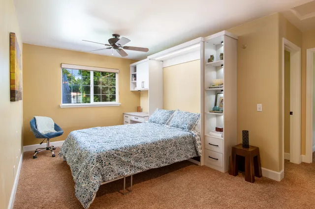 a bedroom with a bed and windows