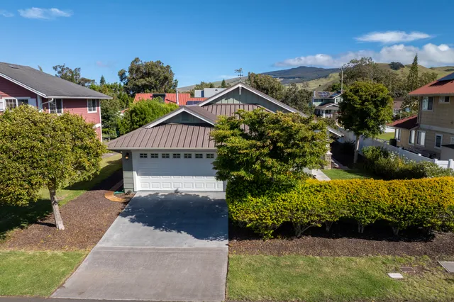a view of a house with a yard and potted plants