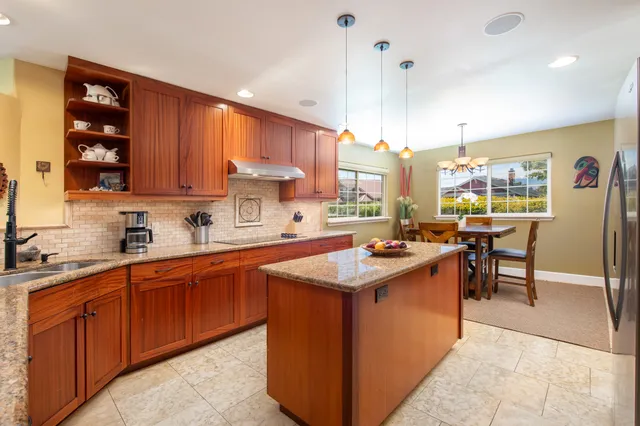 a kitchen with stainless steel appliances granite countertop wooden cabinets sink and a stove