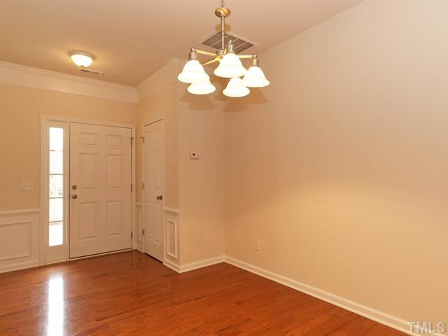 7122 Racine Way Raleigh, NC 27615 - Photo 2 of 20 The foyer greets you with crown, wainscoting, and gleaming hardwood floors.