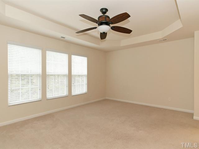 7122 Racine Way Raleigh, NC 27615 - Photo 9 of 20 Sleep well in the spacious master suite that boasts a trey ceiling, plush carpet, and a wall of windows.