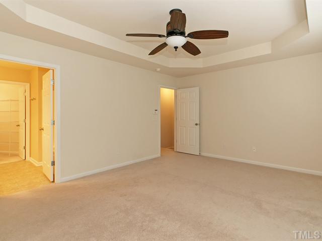 7122 Racine Way Raleigh, NC 27615 - Photo 10 of 20 Sleep well in the spacious master suite that boasts a trey ceiling, plush carpet, and a wall of windows.