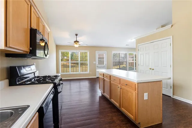 a kitchen with a stove and wooden floor