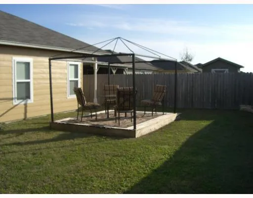 a view of a backyard with table and chairs with wooden fence