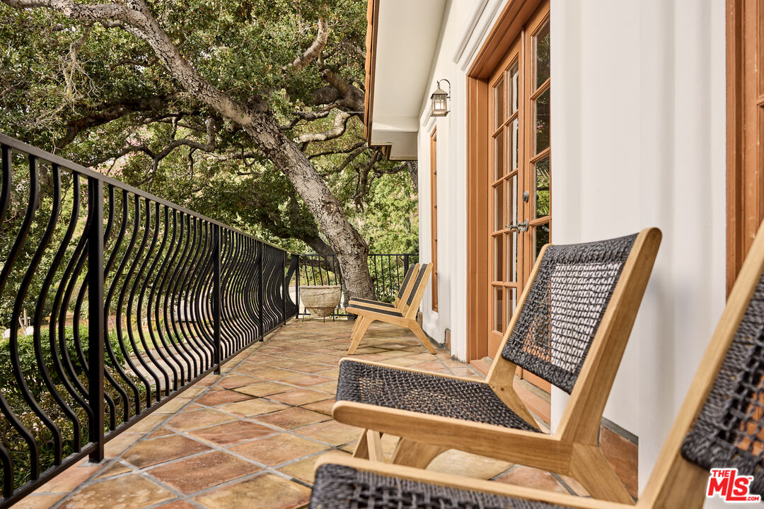 3268 Serra Road Malibu, CA 90265 - Photo 23 of 24 a balcony with wooden floor and outdoor seating