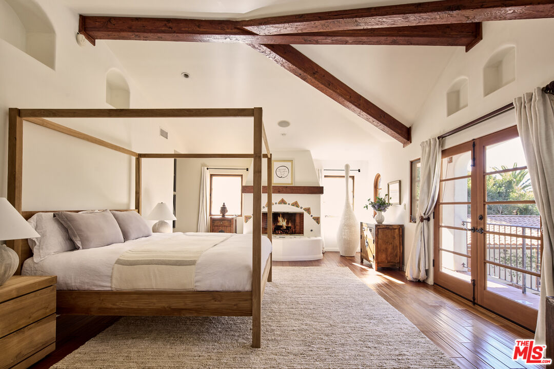 3268 Serra Road Malibu, CA 90265 - Photo 9 of 24 a bedroom with a large bed and a chandelier