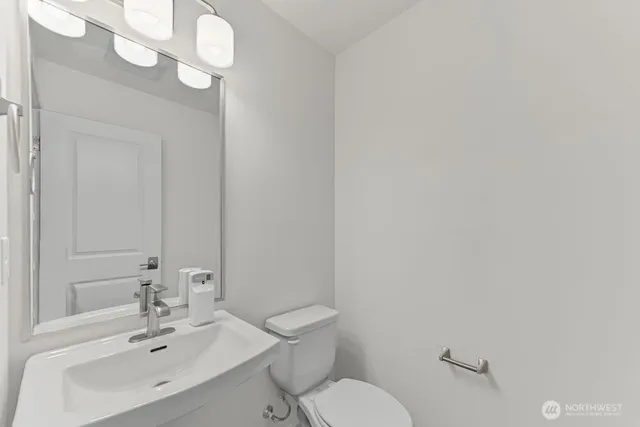 a bathroom with a sink a toilet and mirror