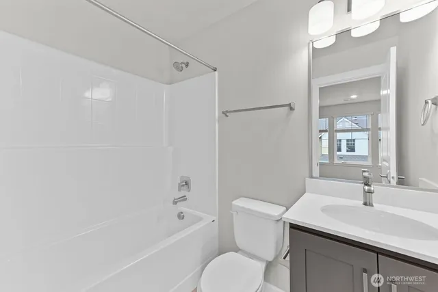 a bathroom with a sink a toilet a mirror and shower