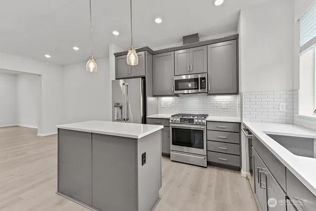 a kitchen with stainless steel appliances a sink stove and refrigerator