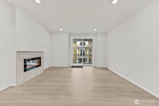 an empty room with windows and fireplace