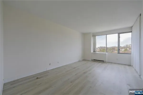 a view of an empty room with wooden floor