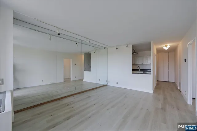a kitchen with cabinets stainless steel appliances and wooden floor