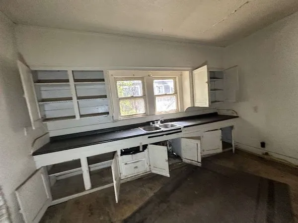 a kitchen with granite countertop a stove and white cabinets