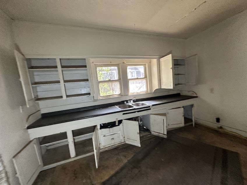 107 Electra Street Longview, TX 75602 - Photo 8 of 12 a kitchen with granite countertop a stove and white cabinets
