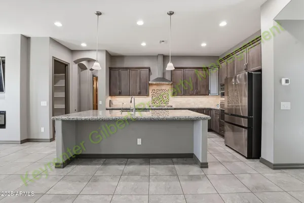 a large kitchen with kitchen island granite countertop a large counter top and stainless steel appliances