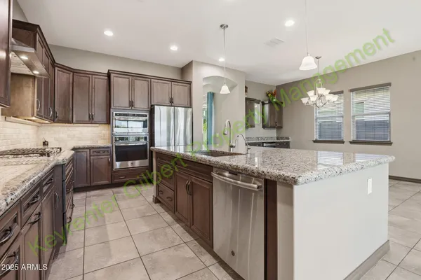 a large kitchen with granite countertop a sink and a stove