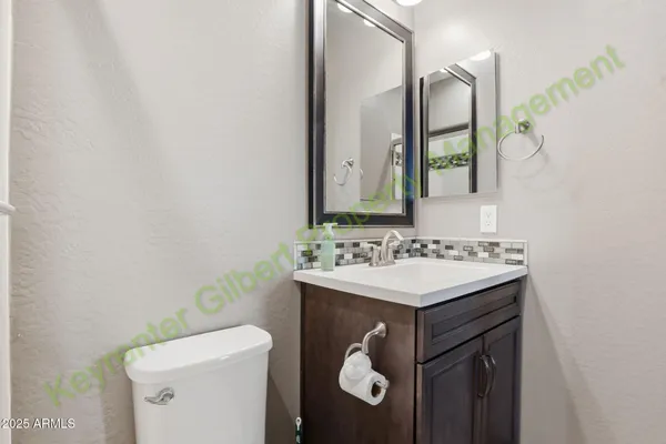 a bathroom with a sink a toilet a mirror a vanity and shower