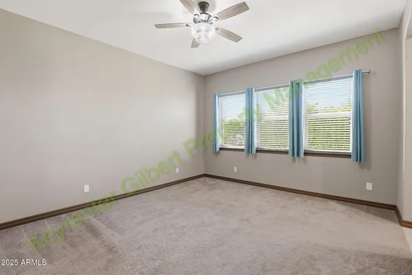 an empty room with closet and a chandelier fan