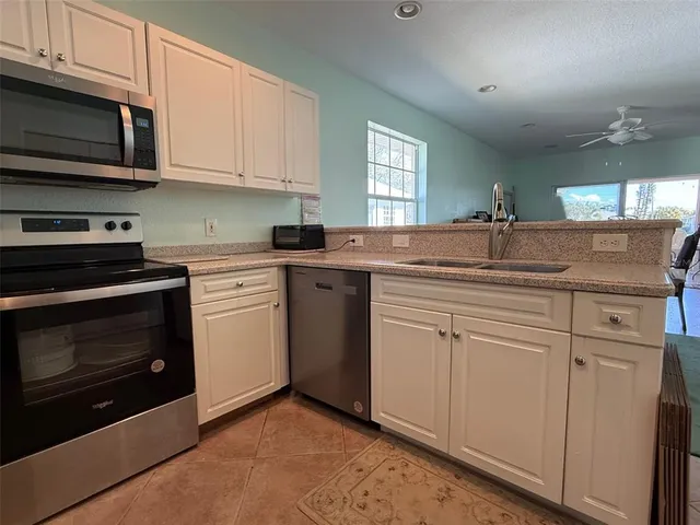 a kitchen with stainless steel appliances granite countertop a sink stove and microwave