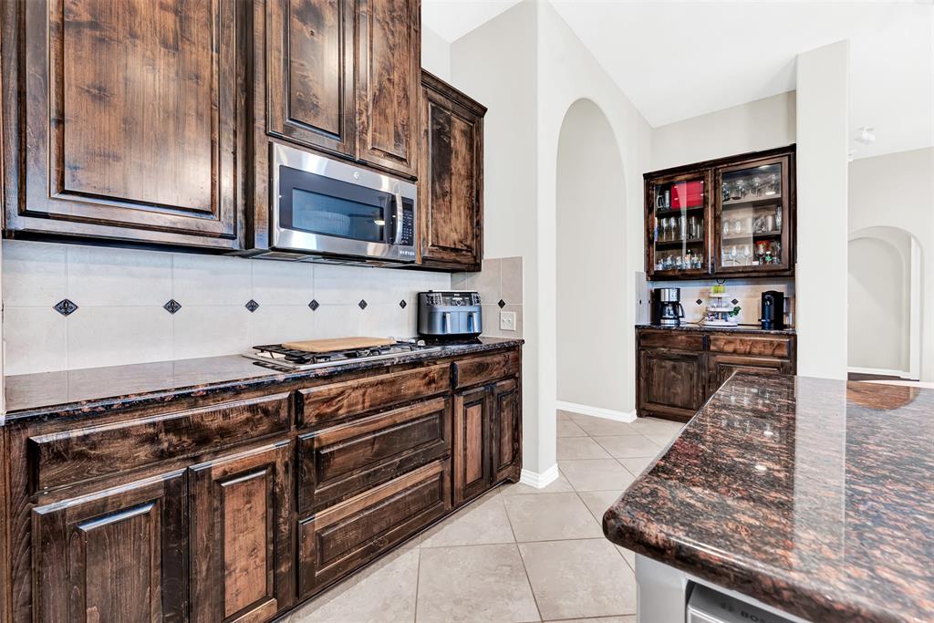 10104 Gentry Drive Frisco, TX 75035 - Photo 10 of 39 a kitchen with stainless steel appliances granite countertop a stove and a microwave