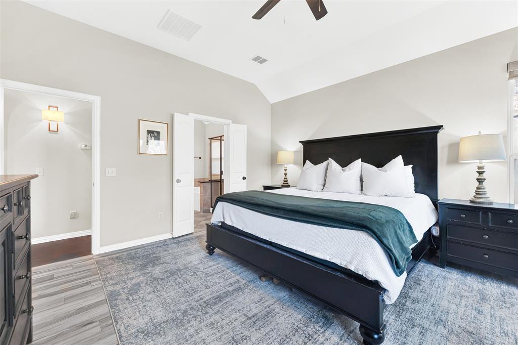 10104 Gentry Drive Frisco, TX 75035 - Photo 17 of 39 a spacious bedroom with a bed and wooden floor