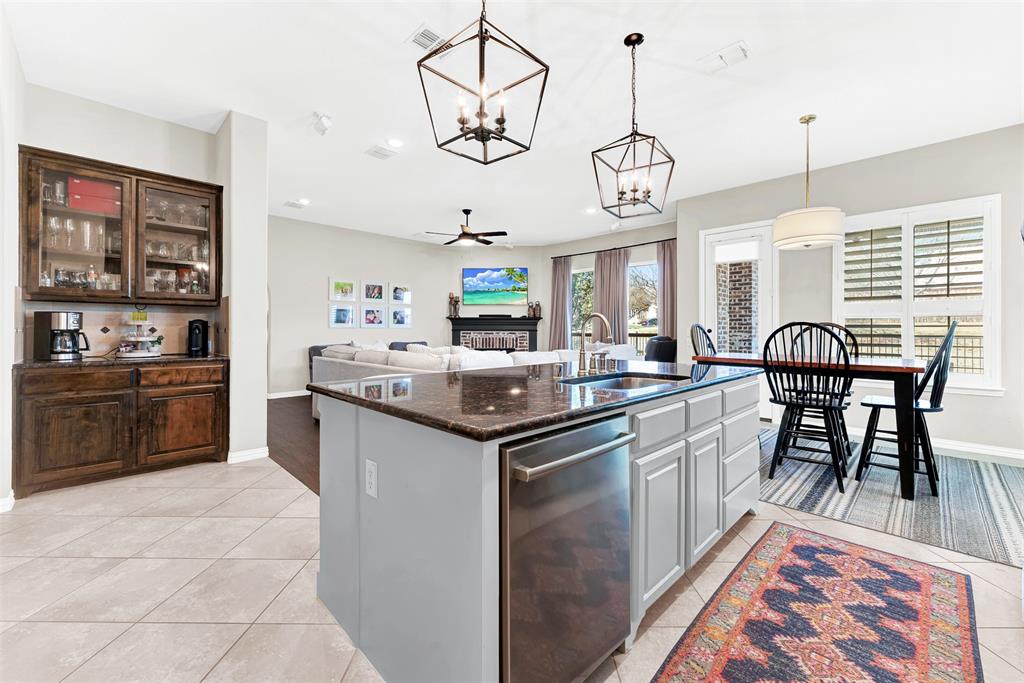 10104 Gentry Drive Frisco, TX 75035 - Photo 39 of 39 a kitchen with stainless steel appliances granite countertop a stove a sink a dining table and chairs