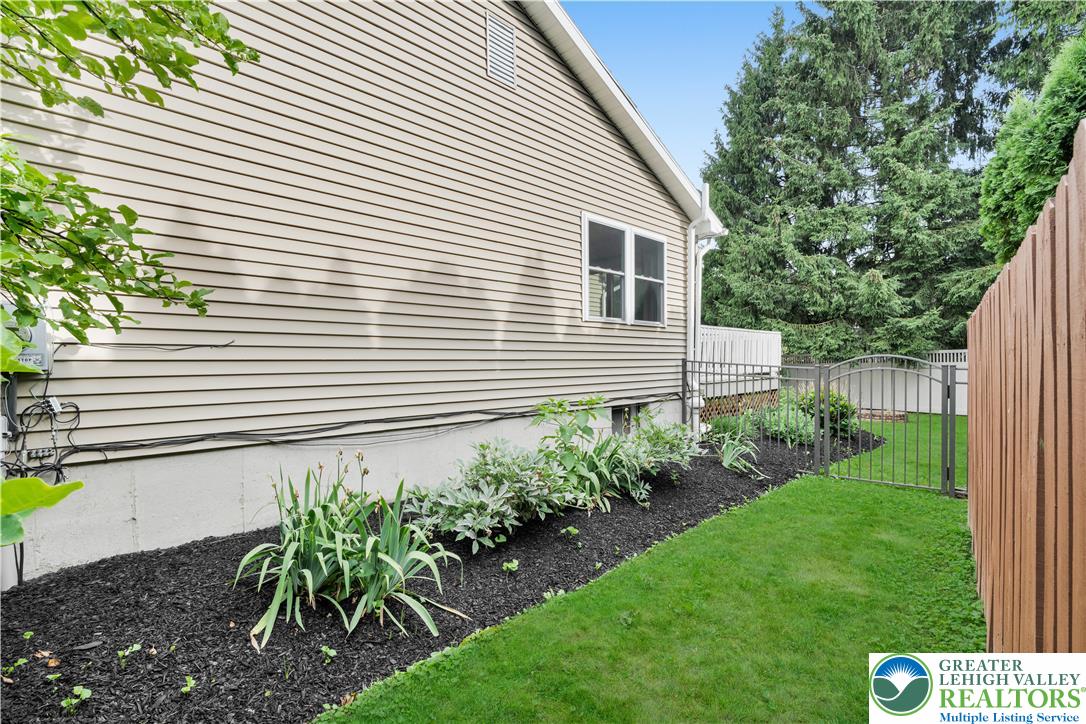 3396 Darien Road Bethlehem, PA 18020 - Photo 43 of 44 A neatly maintained side yard features a privacy fence and a small garden.