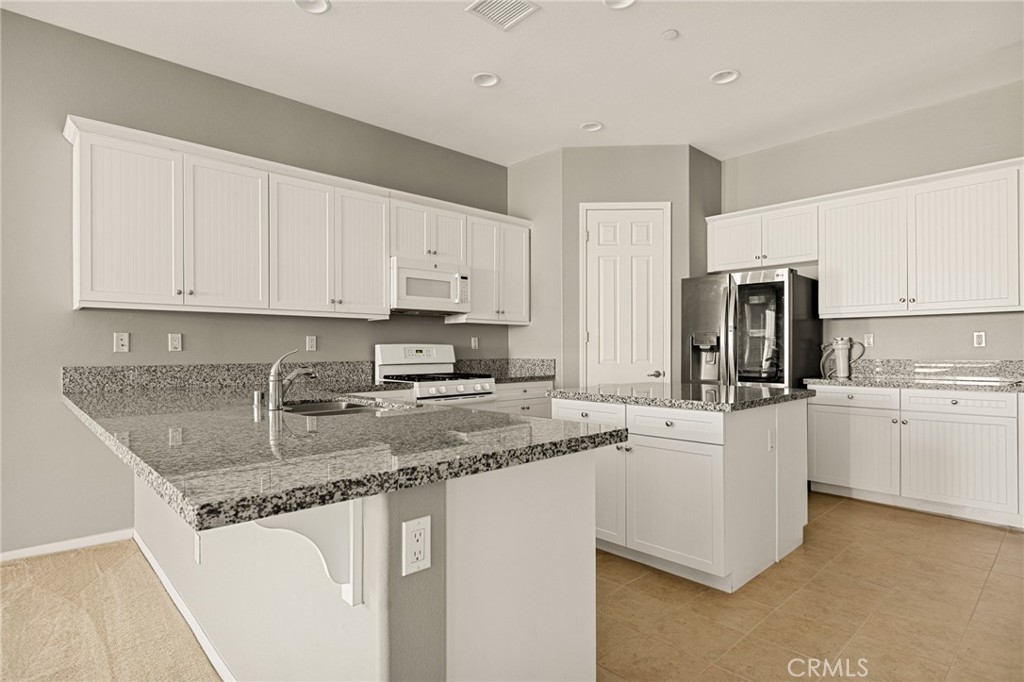 1576 Timberline Beaumont, CA 92223 - Photo 6 of 26 a kitchen with stainless steel appliances granite countertop a sink stove refrigerator and cabinets