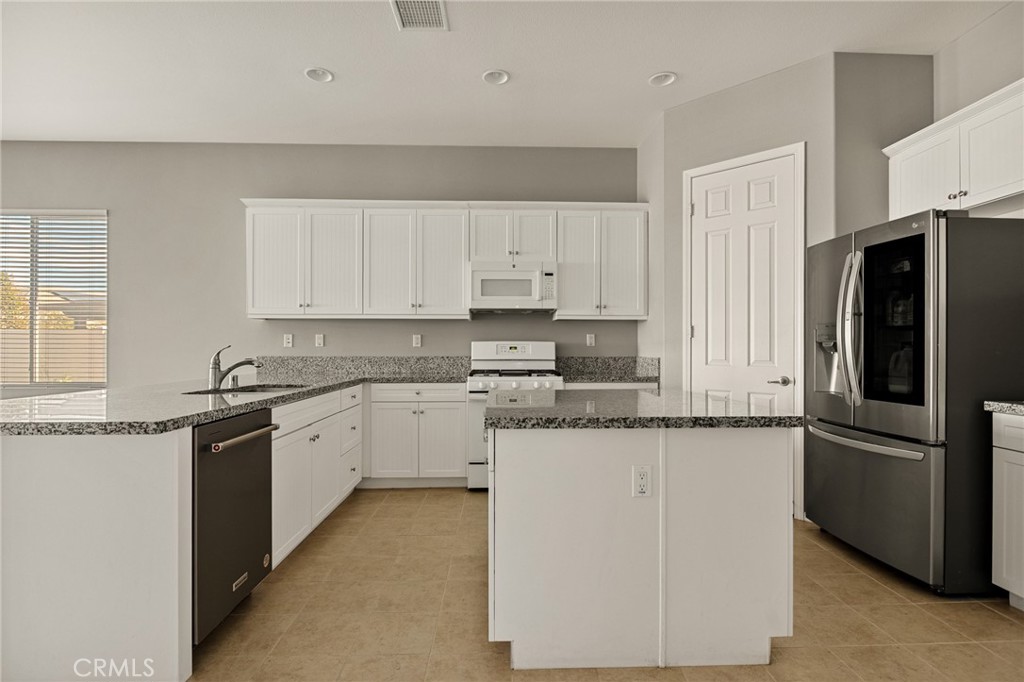 1576 Timberline Beaumont, CA 92223 - Photo 7 of 26 a kitchen with stainless steel appliances granite countertop a refrigerator a stove a sink and white cabinets
