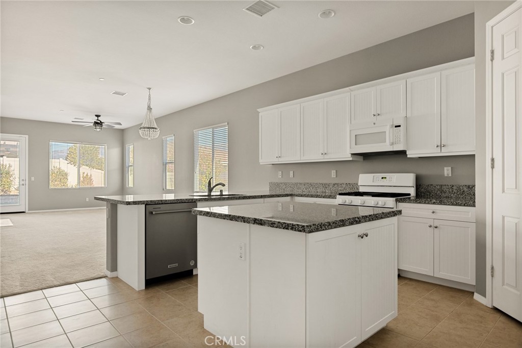 1576 Timberline Beaumont, CA 92223 - Photo 8 of 26 a kitchen with stainless steel appliances granite countertop a stove a sink and a refrigerator