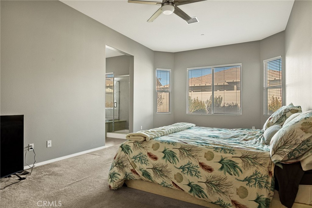 1576 Timberline Beaumont, CA 92223 - Photo 10 of 26 a bed sitting in a bedroom next to a window and a chandelier