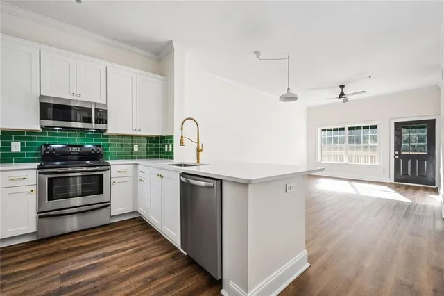 a kitchen with stainless steel appliances kitchen island granite countertop a stove a sink and a microwave