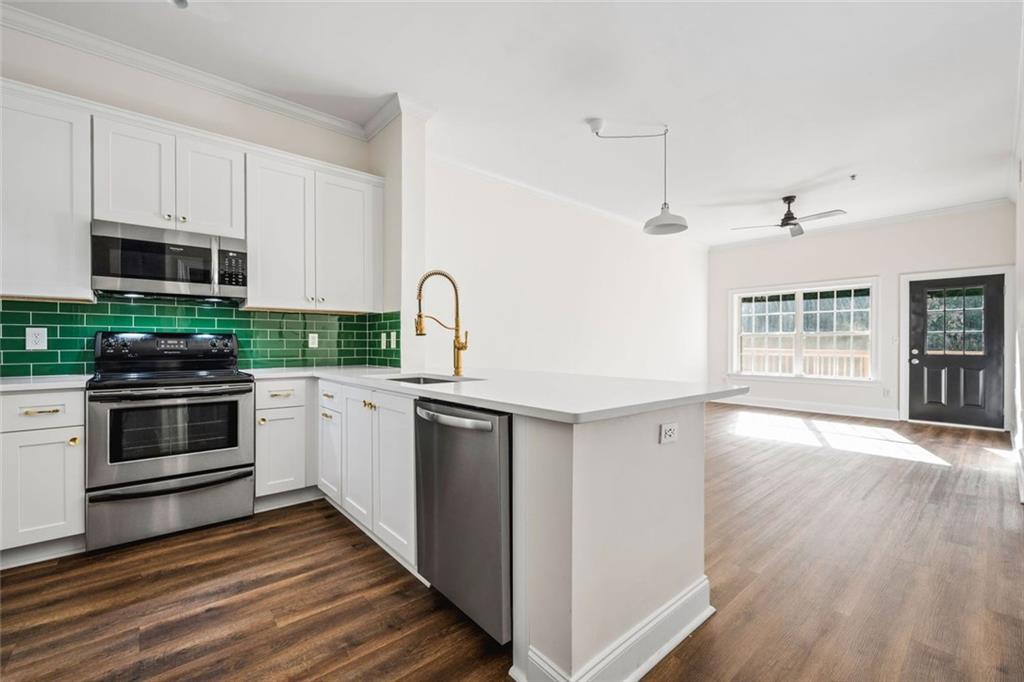 1635 Briarcliff Rd Road, Unit 8 Atlanta, GA 30306 - Photo 1 of 29 a kitchen with stainless steel appliances kitchen island granite countertop a stove a sink and a microwave