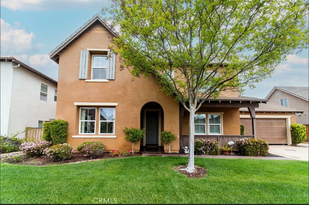 a front view of a house with a garden and yard