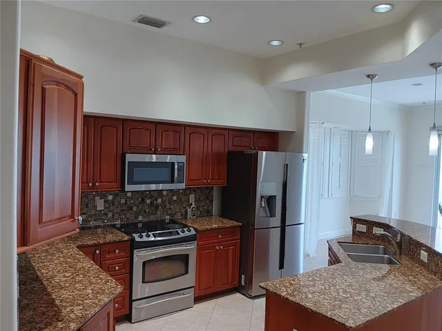 a kitchen with stainless steel appliances granite countertop a refrigerator stove and sink