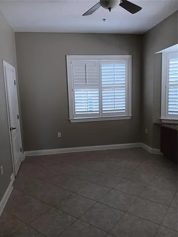 an empty room with a window and a ceiling fan
