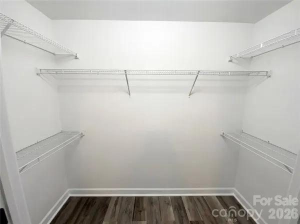 a view of walk in closet with empty racks