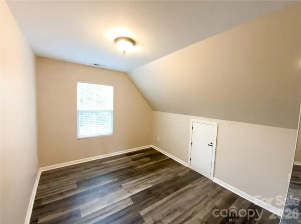 a view of a room with wooden floor and white walls