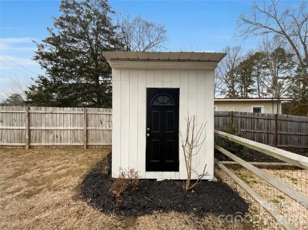 a view of a house with a small yard and wooden fence