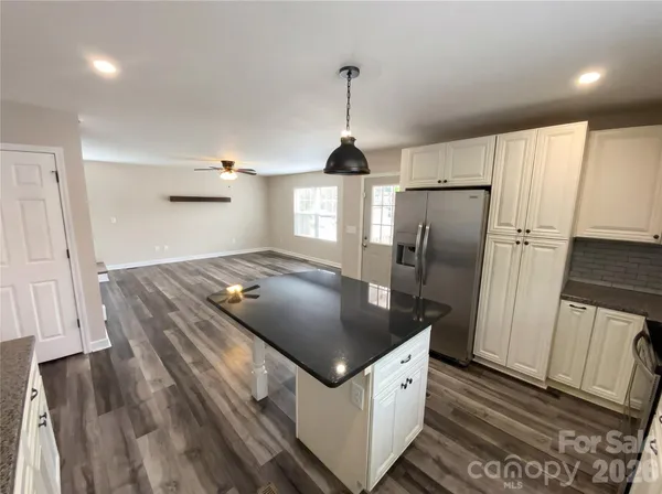 a kitchen with stainless steel appliances granite countertop a sink a refrigerator and a stove
