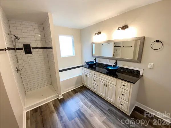 a kitchen with granite countertop a sink cabinets and wooden floor