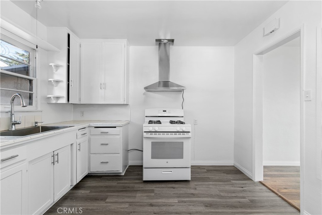 a kitchen with a stove cabinets and wooden floor