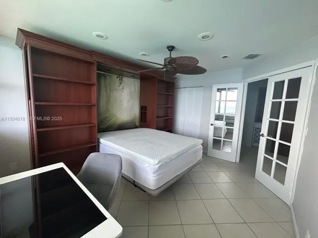 a bedroom with a bed and a ceiling fan