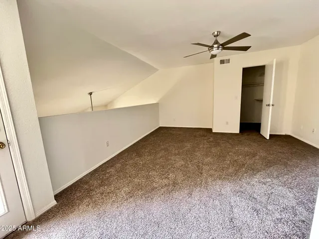 a view of a room with a ceiling fan and closet